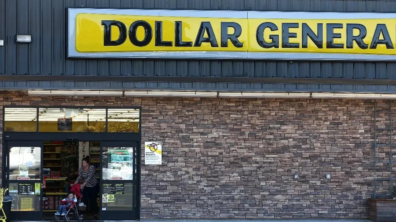 A customer exits a Dollar General store pushing her child in a stroller.